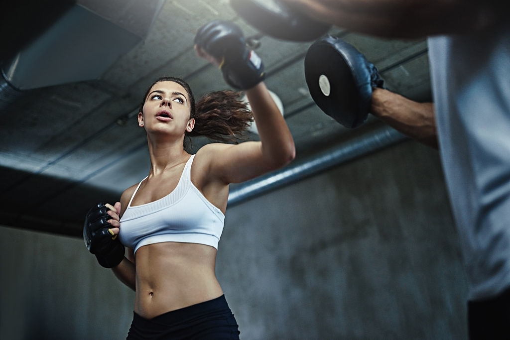 Shot of a young woman sparring with a boxing partner at the gym